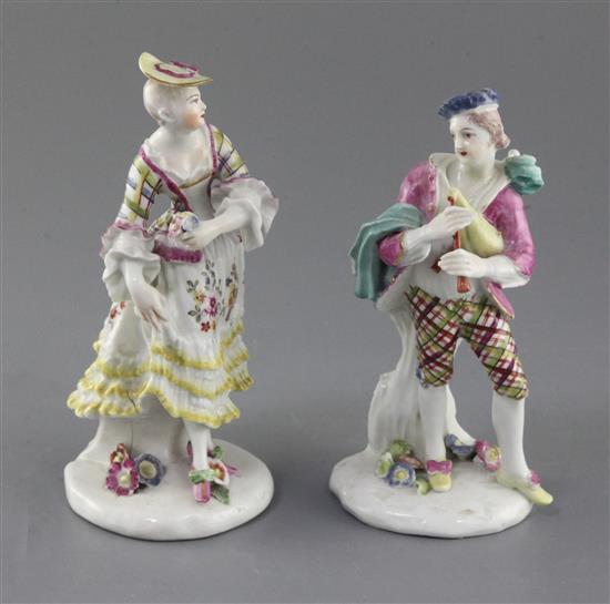 A pair of early Derby figures of a bagpiper and female companion, c.1756-7, h. 15.5cm and 16.5cm, bagpipers neck repaired